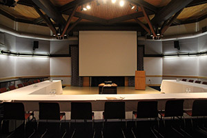 A large corporate meeting room with a projector and screen at The Village at Black Creek