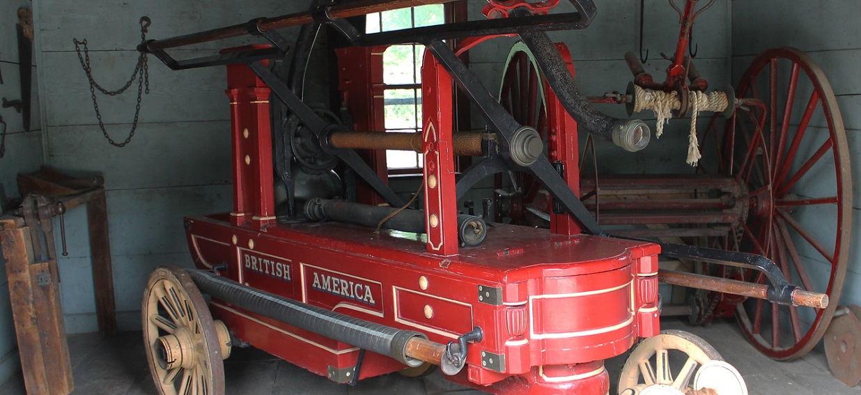 an 1837 fire pumper housed within the fire house at The Village at Black Creek