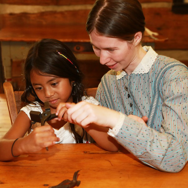 Black Creek history actor with student during home school day event