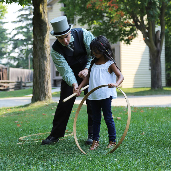 Black Creek history actor with student during home school day event