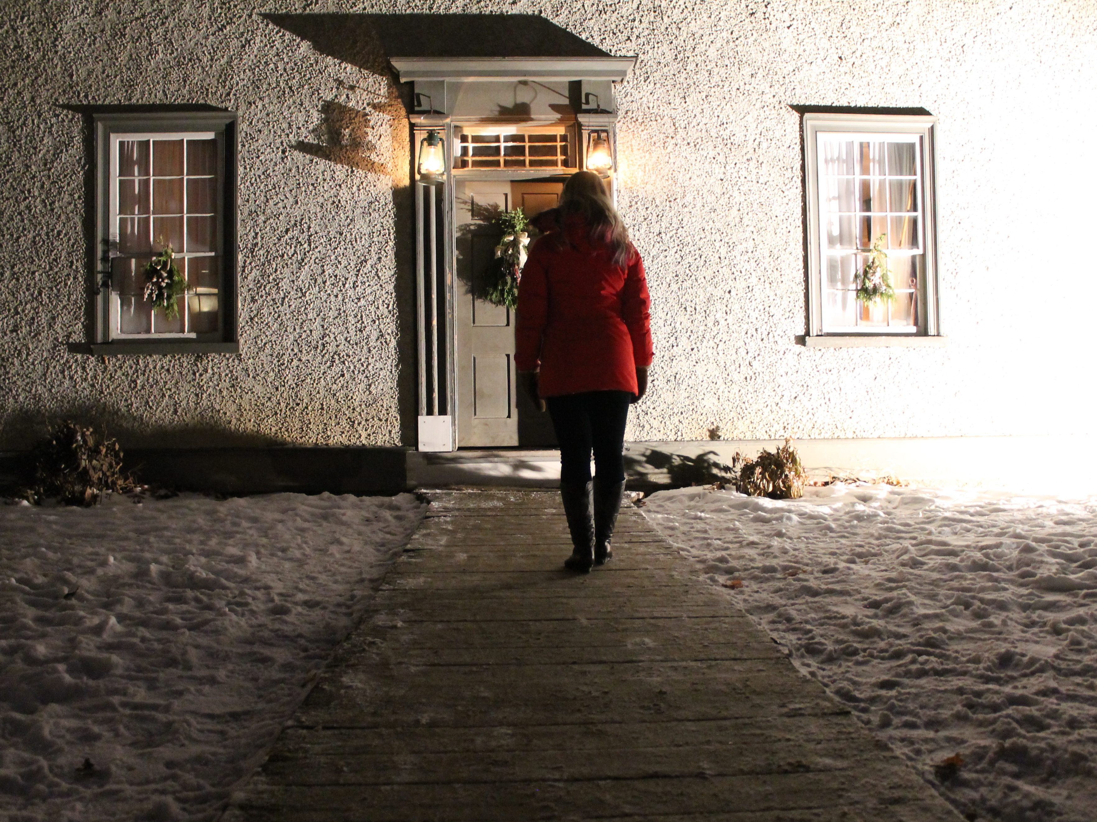 A woman walking toward a pioneer house