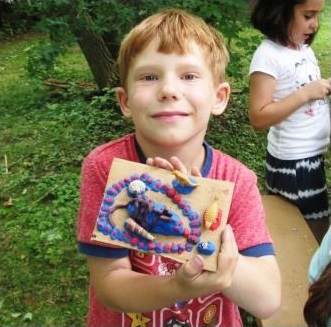 young boy makes crafts at Black Creek Village summer day camp