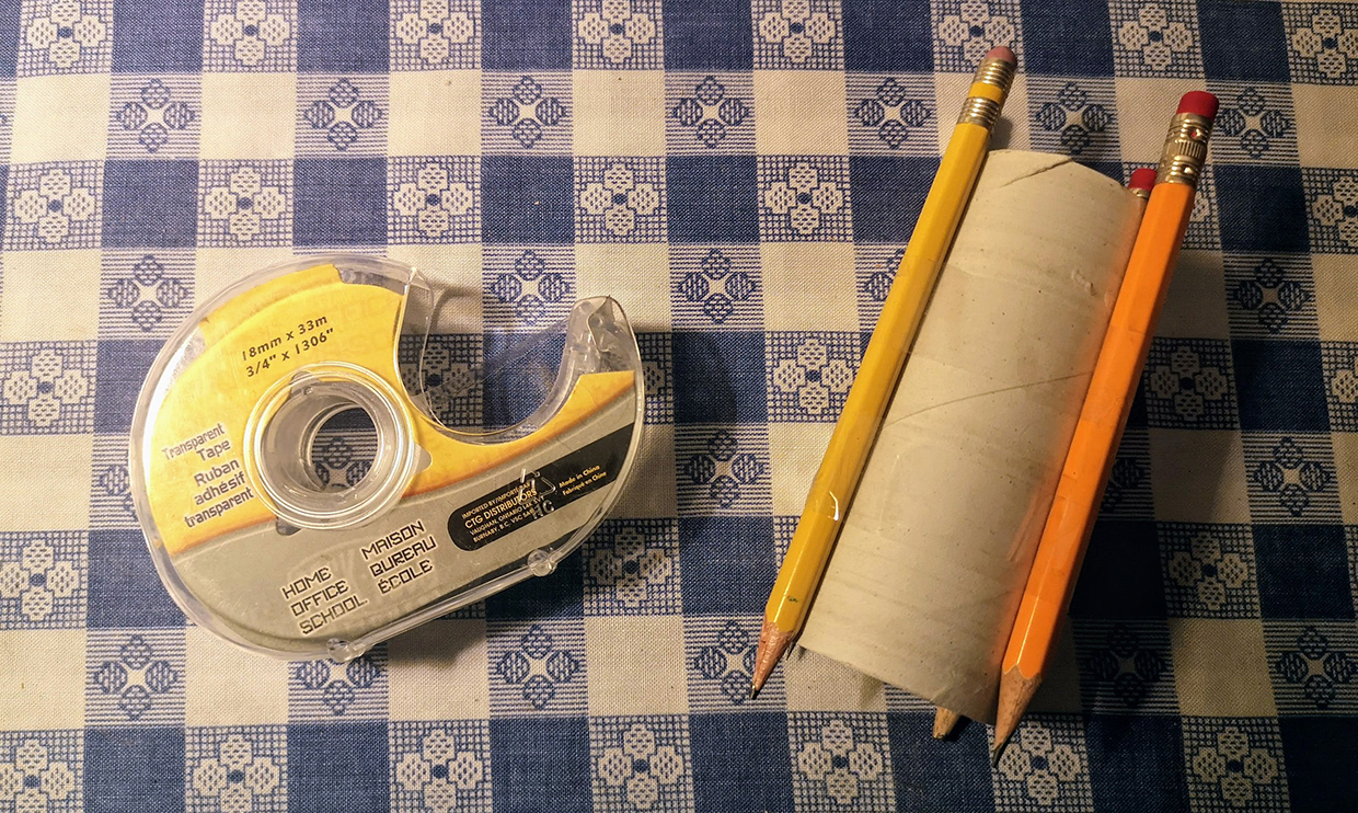 pencils taped to toilet paper roll to form loom