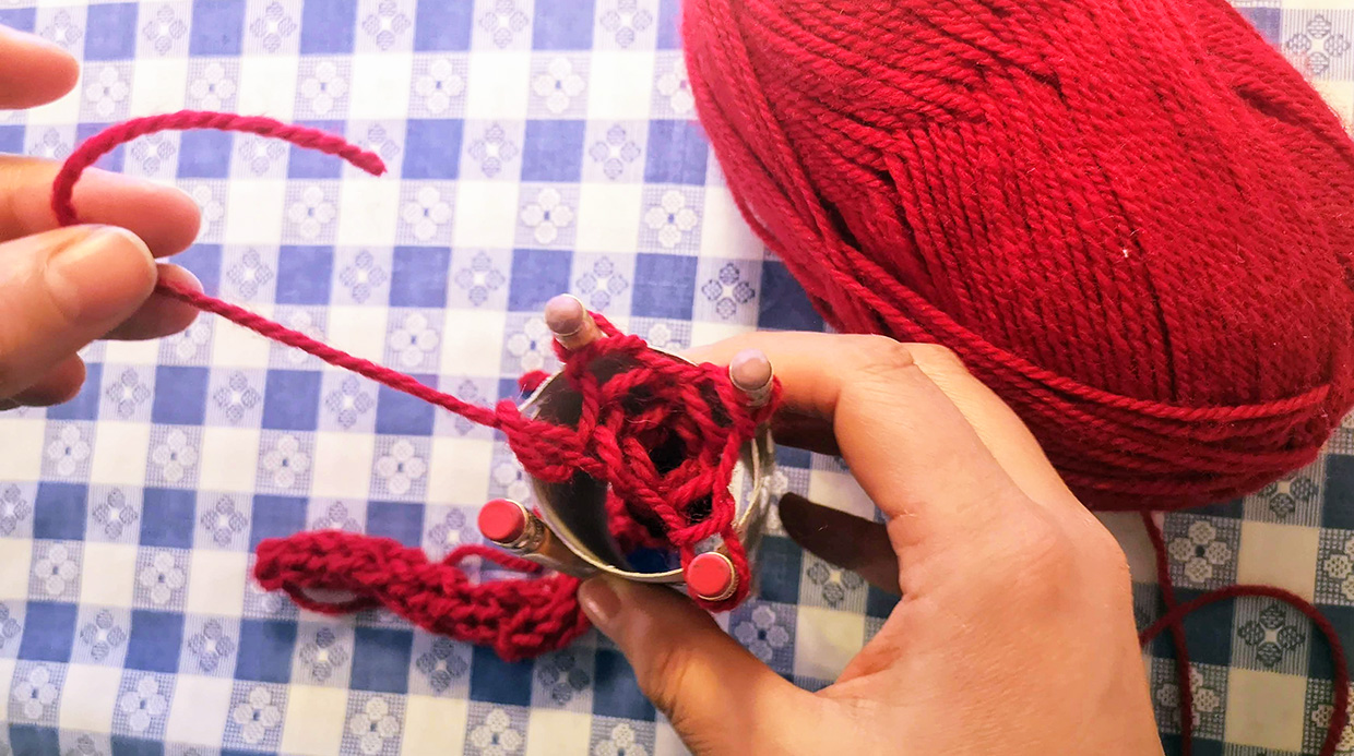 crafter pulls end of yarn through last stitch