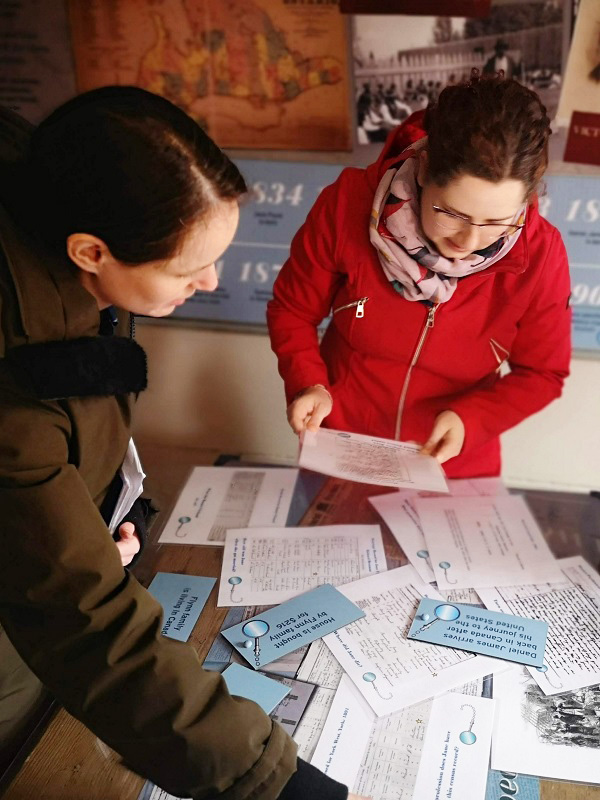 visitors to Flynn House exhibit at The Village at Black Creek explore family records