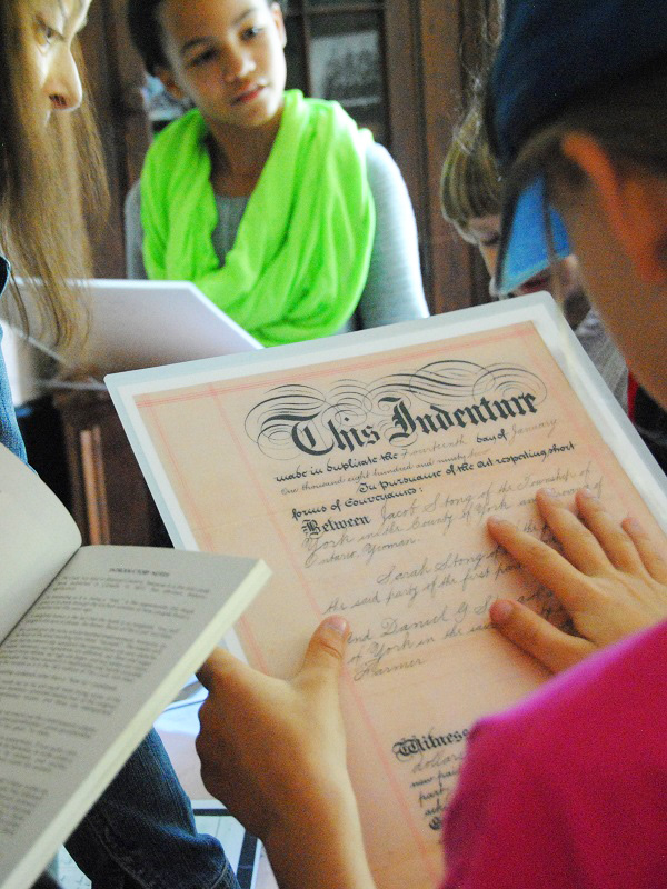 students visiting Flynn House exhibit at The Village at Black Creek examine family documents