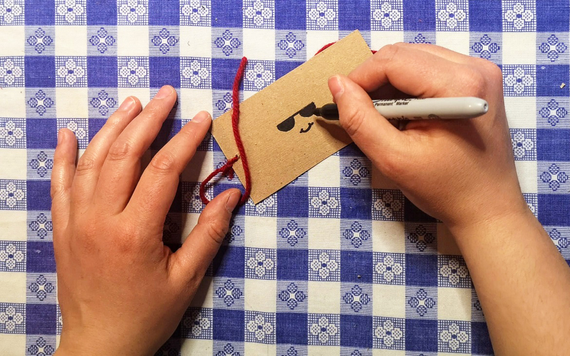 crafter draws picture of face on one side of piece of cardboard to make an optical toy