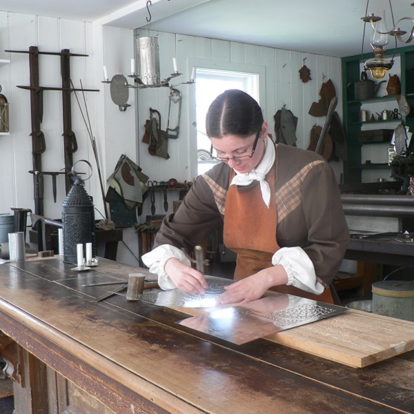 a tinsmith at work in her shop