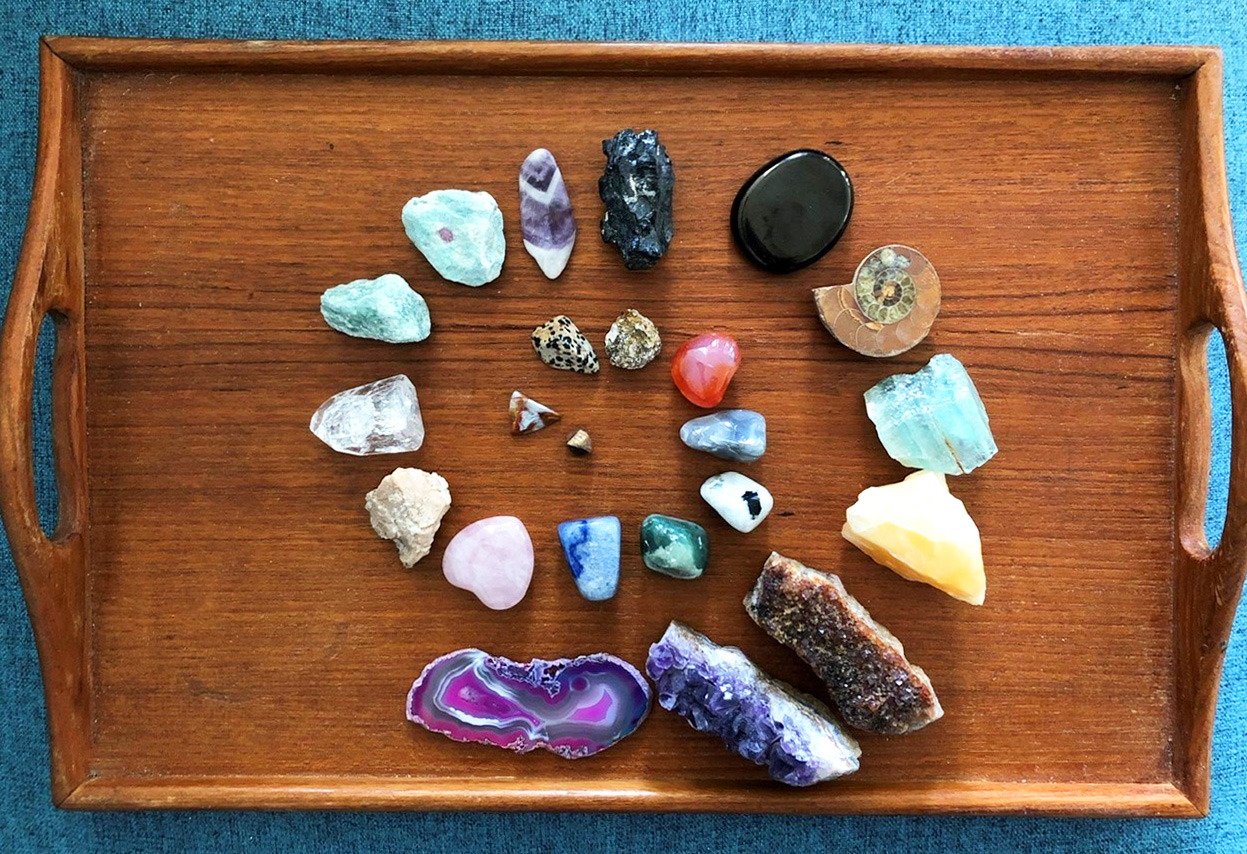 a collection of unusual rocks organized by size on a wooden tray