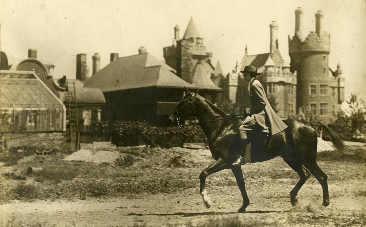 1920s photograph of woman wearing jodhpurs as she rides horseback near Casa Loma in Toronto