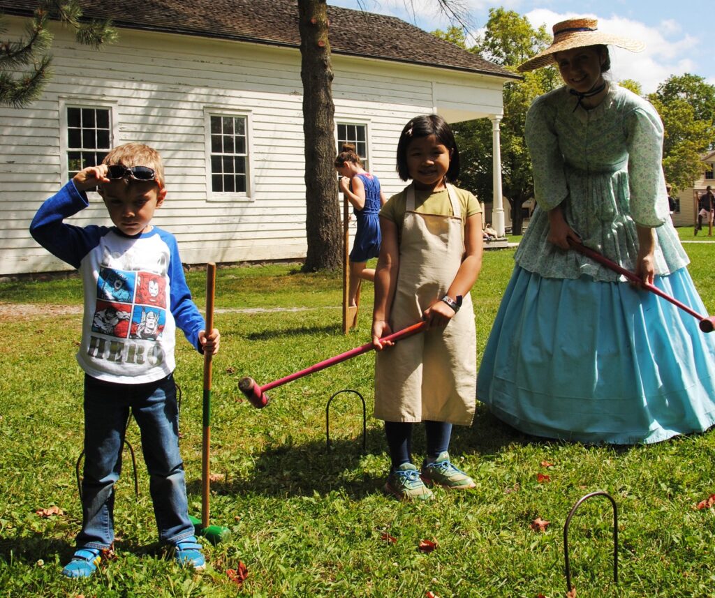 Events 6 children play croquet with costumed educator on a summer day at Black Creek Pioneer Village