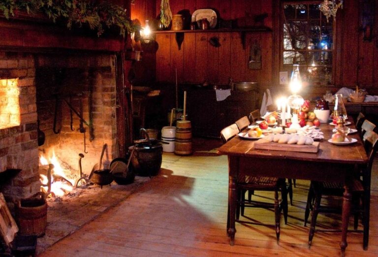 Interior of historic building gently lit by candle and fireplace for Christmas High Street by Night event at Black Creek Pioneer Village