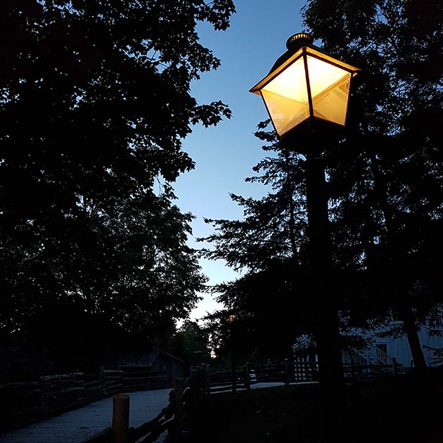 the streets of Black Creek Pioneer Village illuminated by lamplight after dark