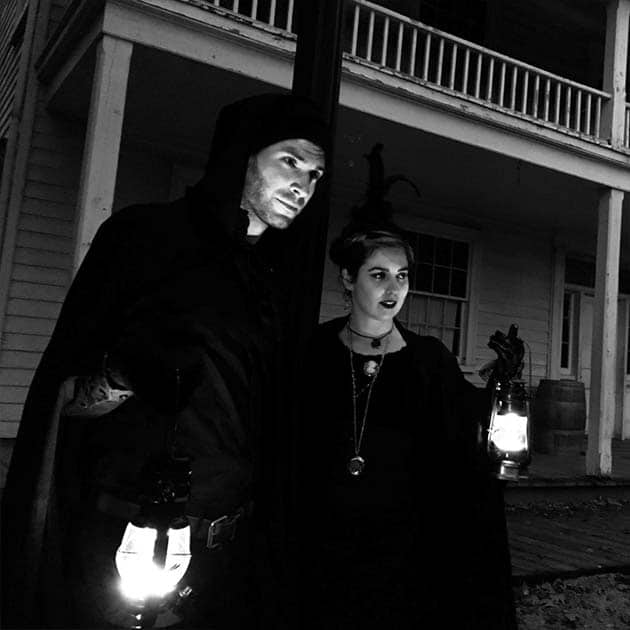 guides with lanterns lead a ghost walk at the Village at Black Creek after dark