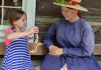 costumed educator and student enjoy playing Victorian-style game at Black Creek Pioneer Village