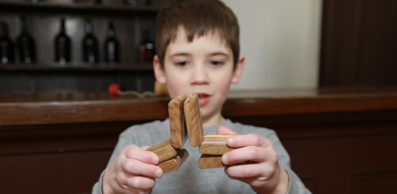 student plays with traditional Victorian wooden toy