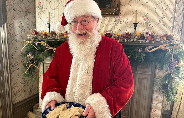 Santa Claus greets visitors to Black Creek Pioneer Village with a plate of cookies during Santa at the Village event