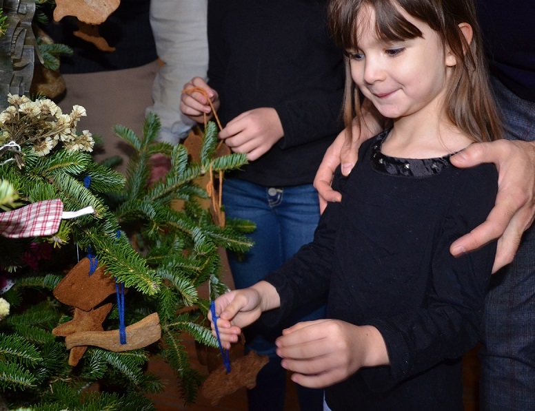 young visitors decorates a Christmas tree at Black Creek Pioneer Village during the holiday season in December