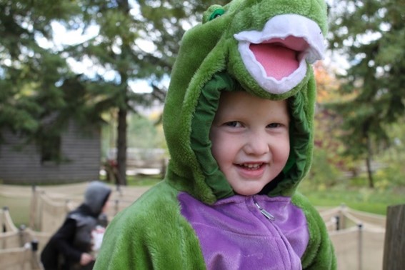 child wears dinosaur costume at Black Creek Pioneer Village Halloween event