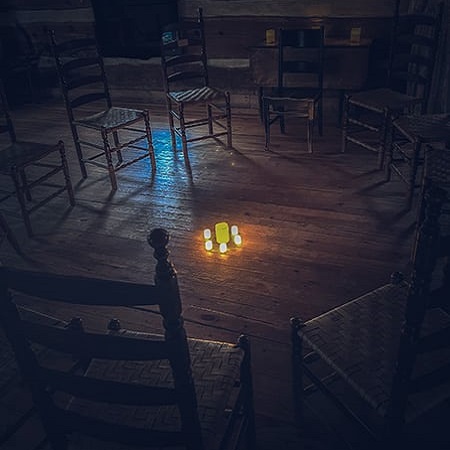chairs gathered in a circle around a glowing candle