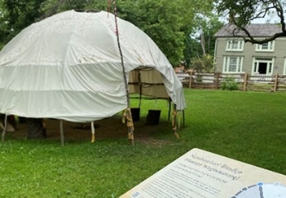 a wiigiwaam accompanied by an informational panel at Black Creek Pioneer Village