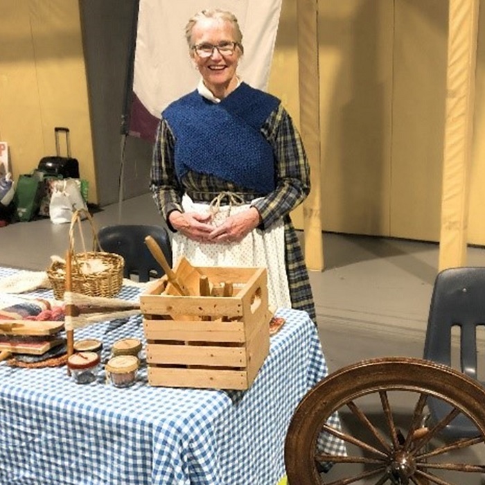 a costumed educator hosts a presentation of Victorian artifacts and objects from Black Creek Village at a community event