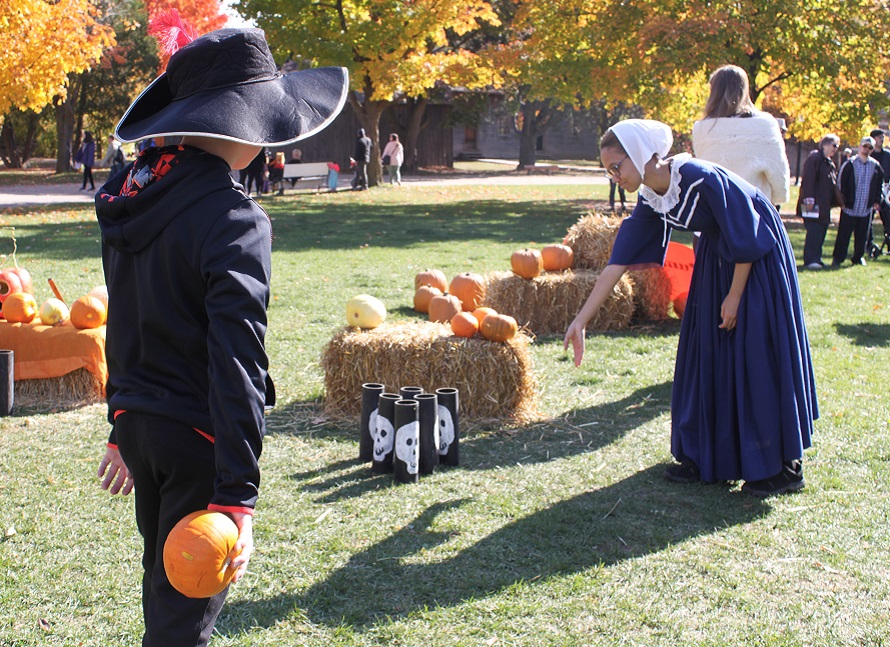 youngster in costume plays Halloween games at the Village at Black Creek