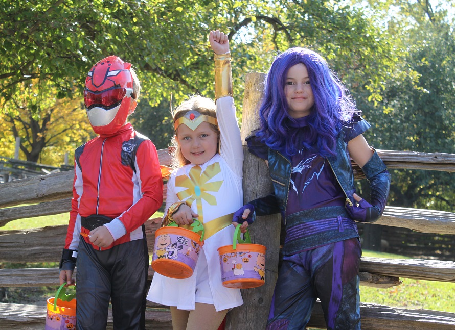 youngsters in superhero costumes enjoy Halloween activities at the Village at Black Creek