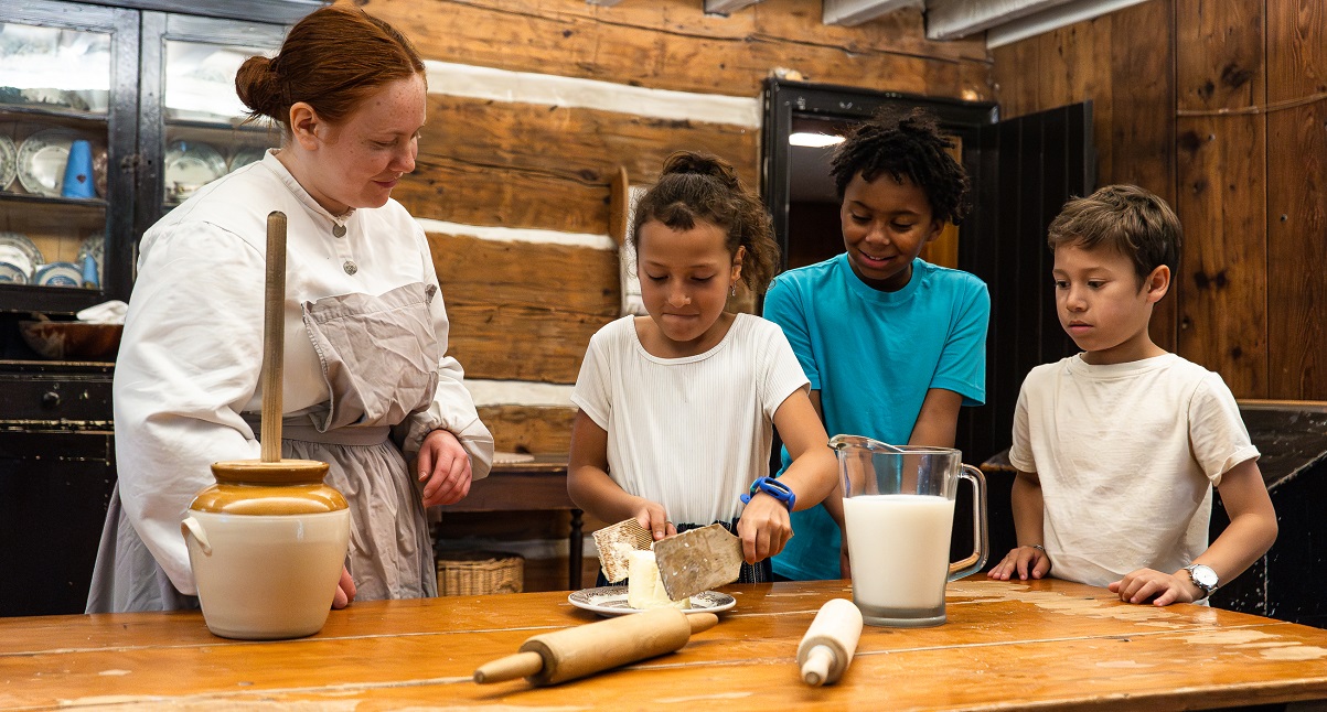 costumed educator at the Village at Black Creek teaches students how to prepare a traditional 19th century recipe