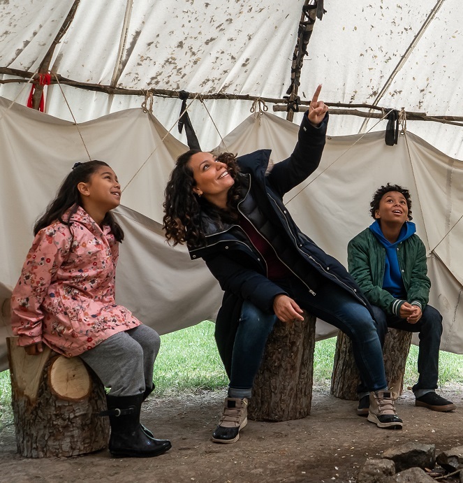 a young family explores a traditional Wiigiwaam at the Village at Black Creek