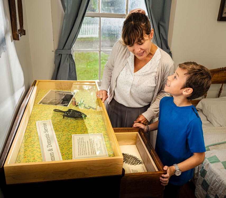 mother and son explore the Flynn House interactive exhibit at the Village at Black Creek