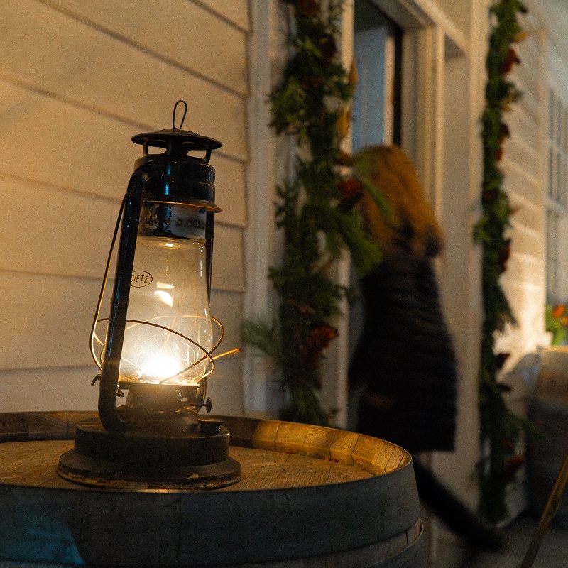 visitors explore The Village at Black Creek by lamplight during the Festive Nights holiday celebration