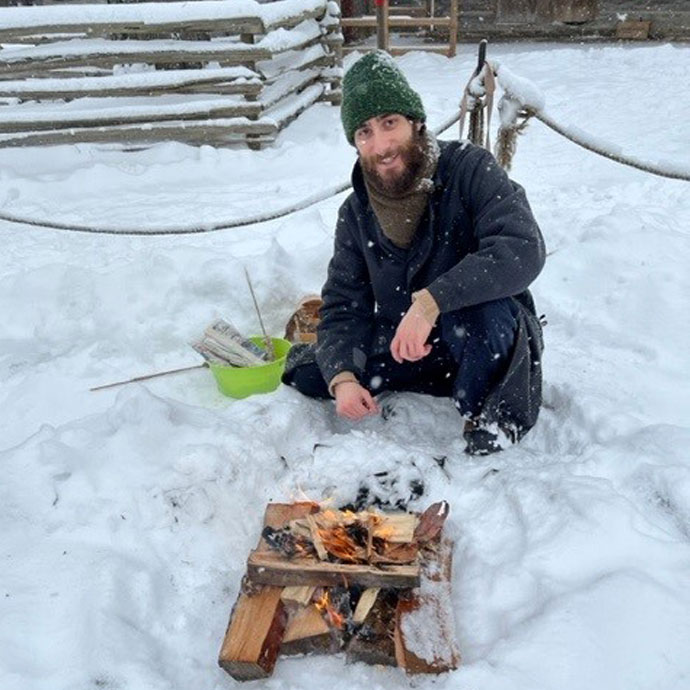 history actor making a fire at the Village at Black Creek on a winter day