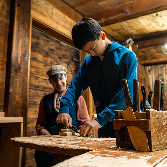 a visitor at the Village at Black Creek experiences 19th century method of wood working