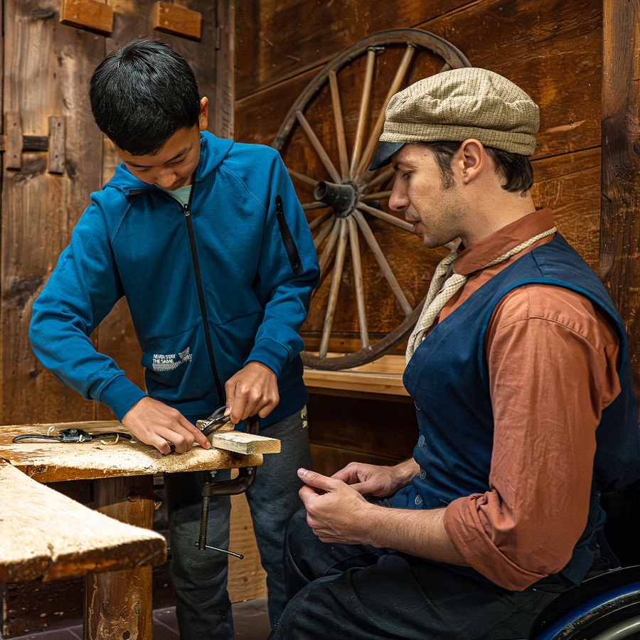 Summer Camp & Teen Experiences at The Village 3 a costumed educator at The Village at Black Creek teaches a summer camper the 19th century method of woodworking