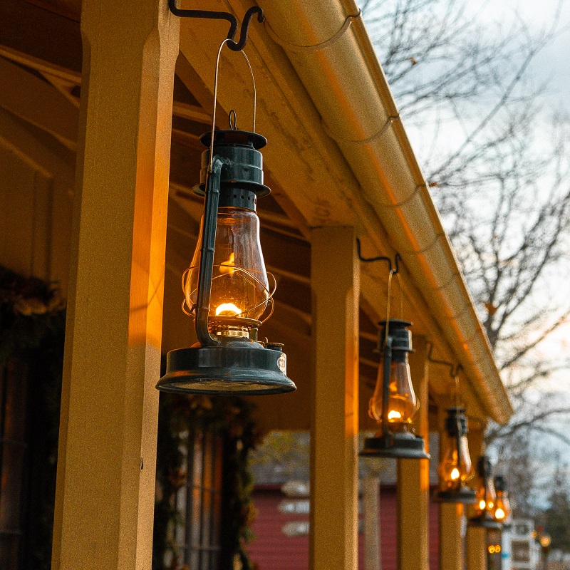 a heritage building at The Village at Black Creek is lit by the glow of lanterns