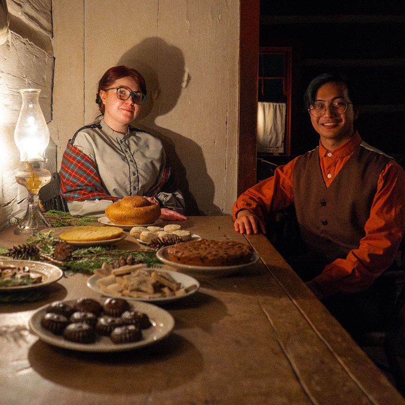 a pair of costumed educators greet visitors to the Festive Nights event at The Village at Black Creek