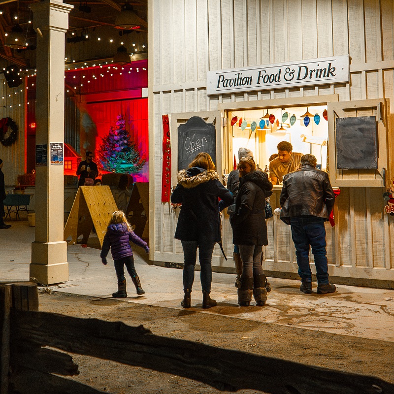 visitors to the Festive Nights event at The Village at Black Creek enjoy food at the Village pavilion