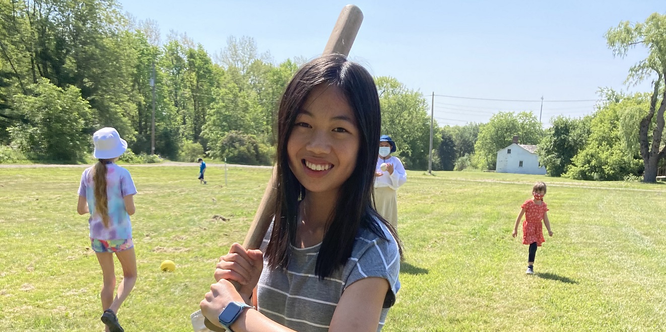a young visitor to The Village at Black Creek takes part in a game of 19th century style baseball