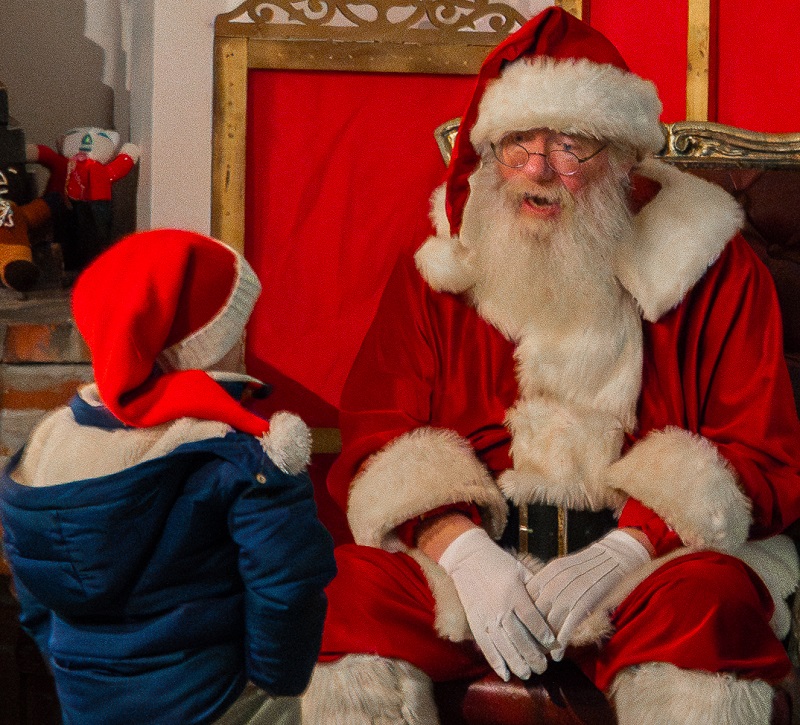 Santa Claus welcomes a young visitor to his workshop at The Village at Black Creek