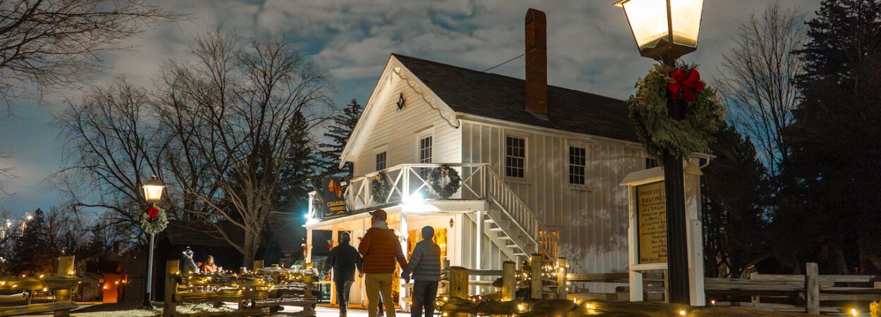 visitors explore The Village at Black Creek by lantern light during the Festive Nights event