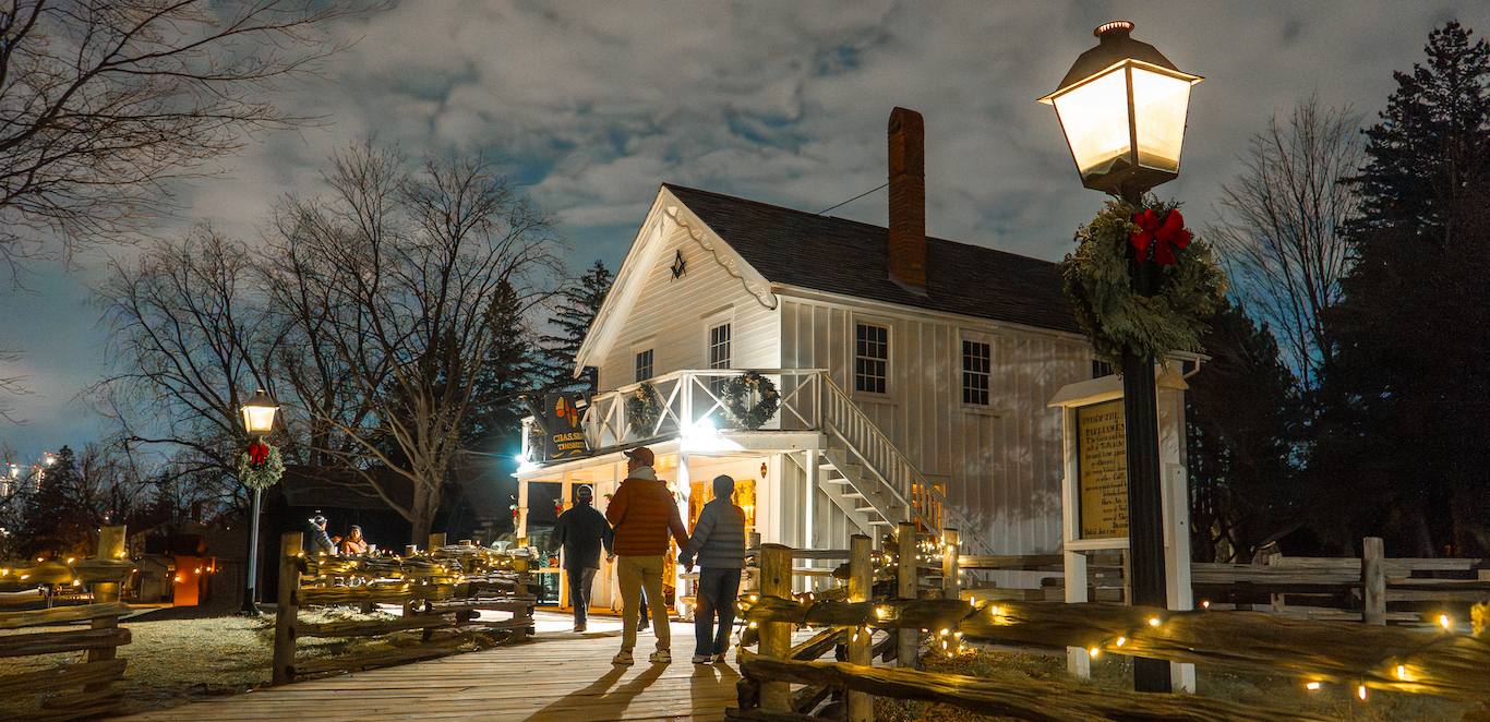 Holidays at The Village 1 visitors explore The Village at Black Creek by lantern light during the Festive Nights event