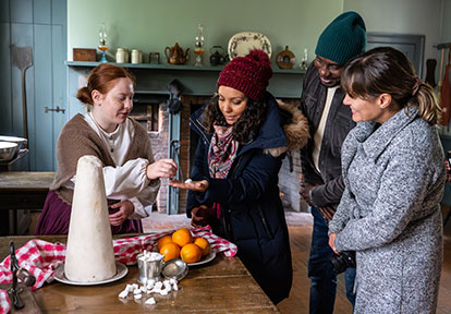 costumed educator at the Village at Black Creek shows visitors how to prepare a traditional 19th century recipe