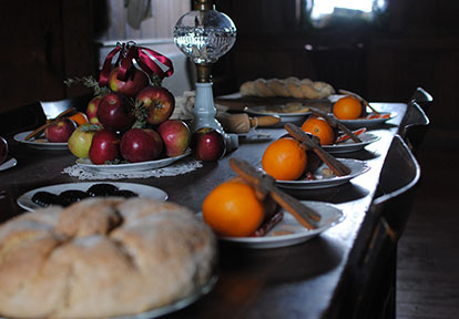 holiday setting with oranges, gingerbread and apple decorated in victorian style dark wood table close up