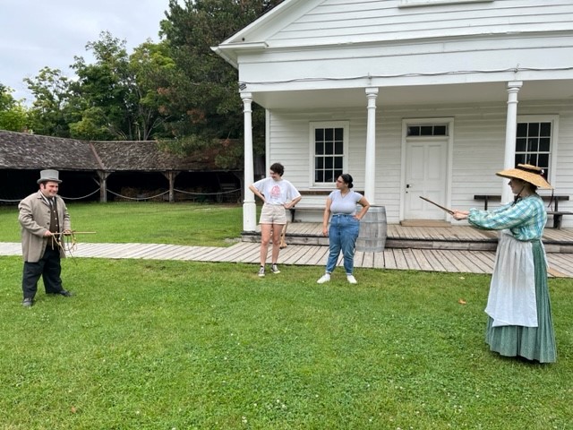 a costumed historian from the Village at Black Creek demonstrates an old-fashioned outdoor games