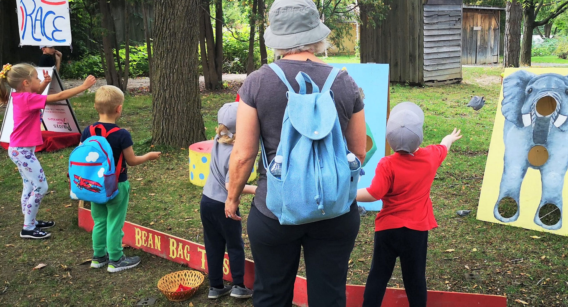 children having fun playing outdoor game with an adult accompanying